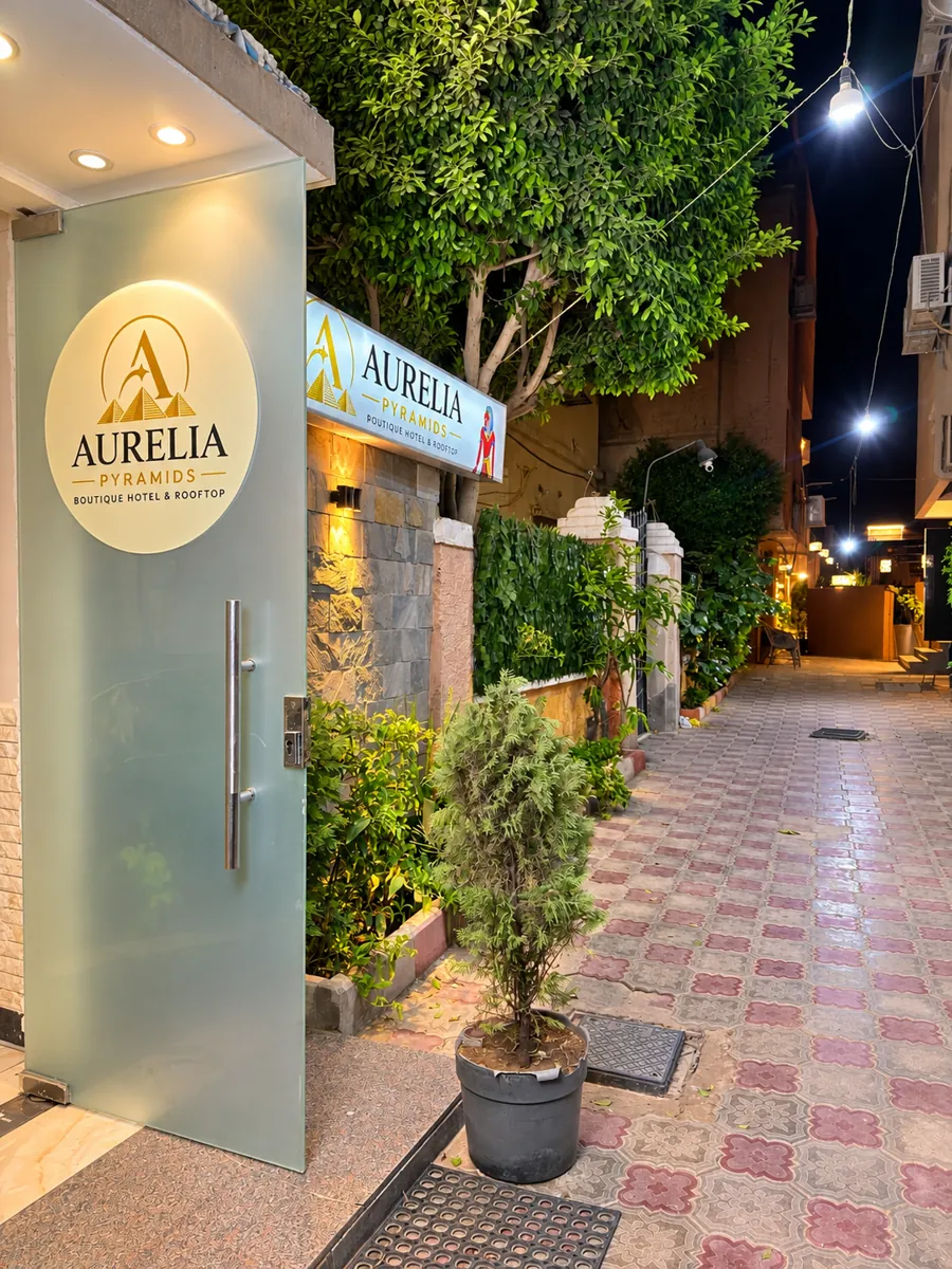 Glass entrance door with the round Aurelia Pyramids logo beside the illuminated sign