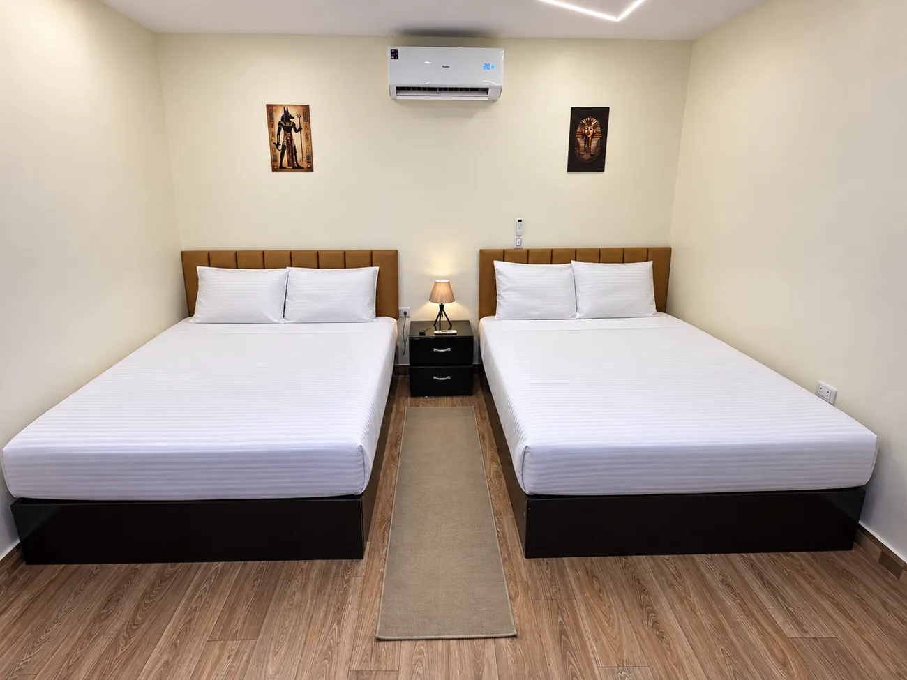 Interior family room 206 with two double beds, padded headboards and a bedside table